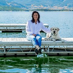 Listing agent on the Dillon Reservoir dock with a yellow lab, Tenmile Range in the background
