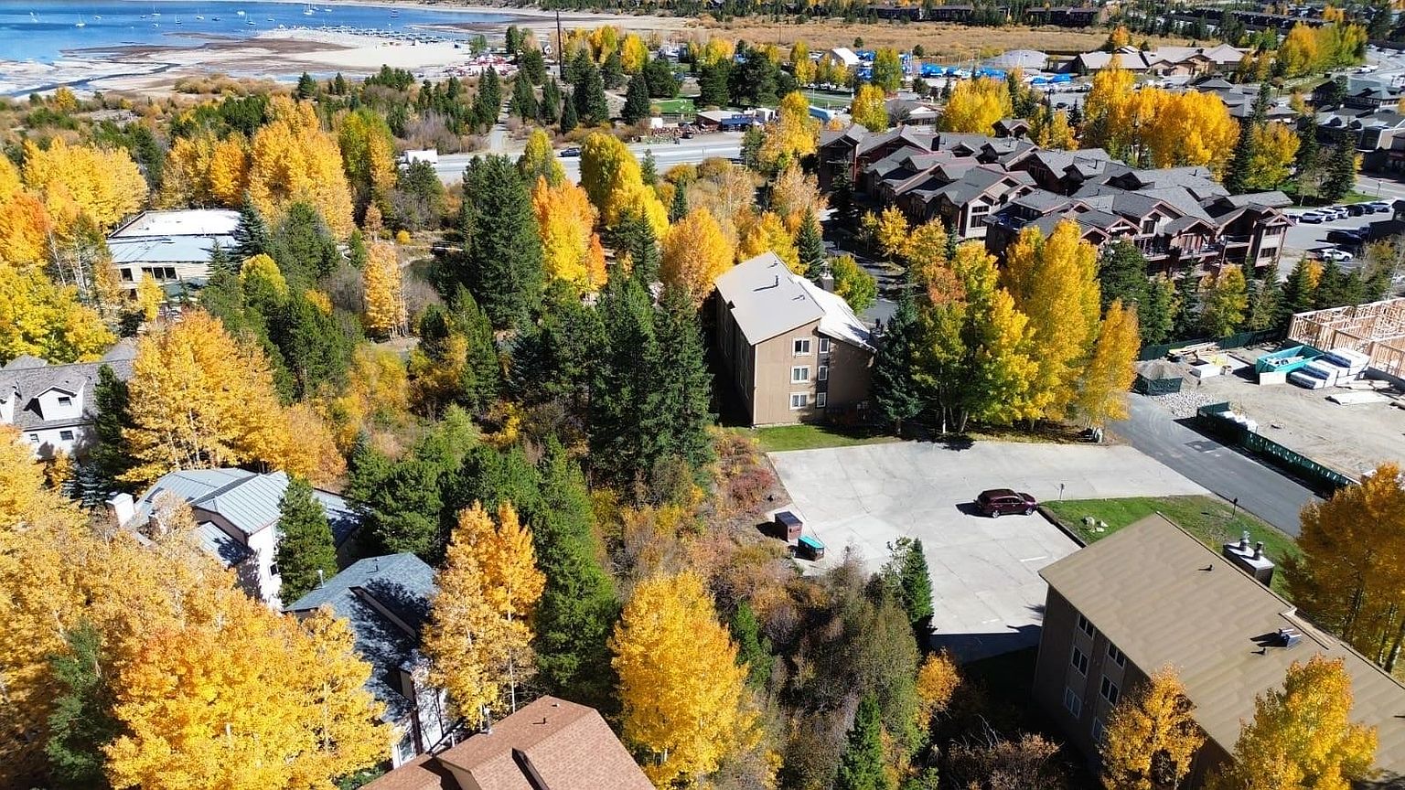 Overhead aerial of the building and grounds, surrounded by aspens at peak fall color, with Dillon Reservoir in the background